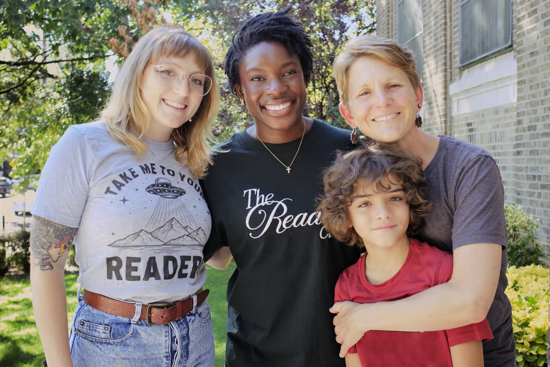 M.A.R.S. mentors, staff, and a young reader smiling together outside